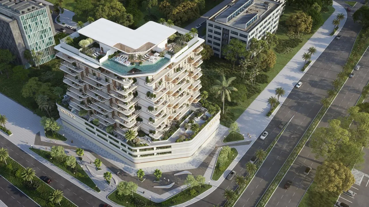 Seen from the air, the building and its roof deck among the wide streets and low blocks around it