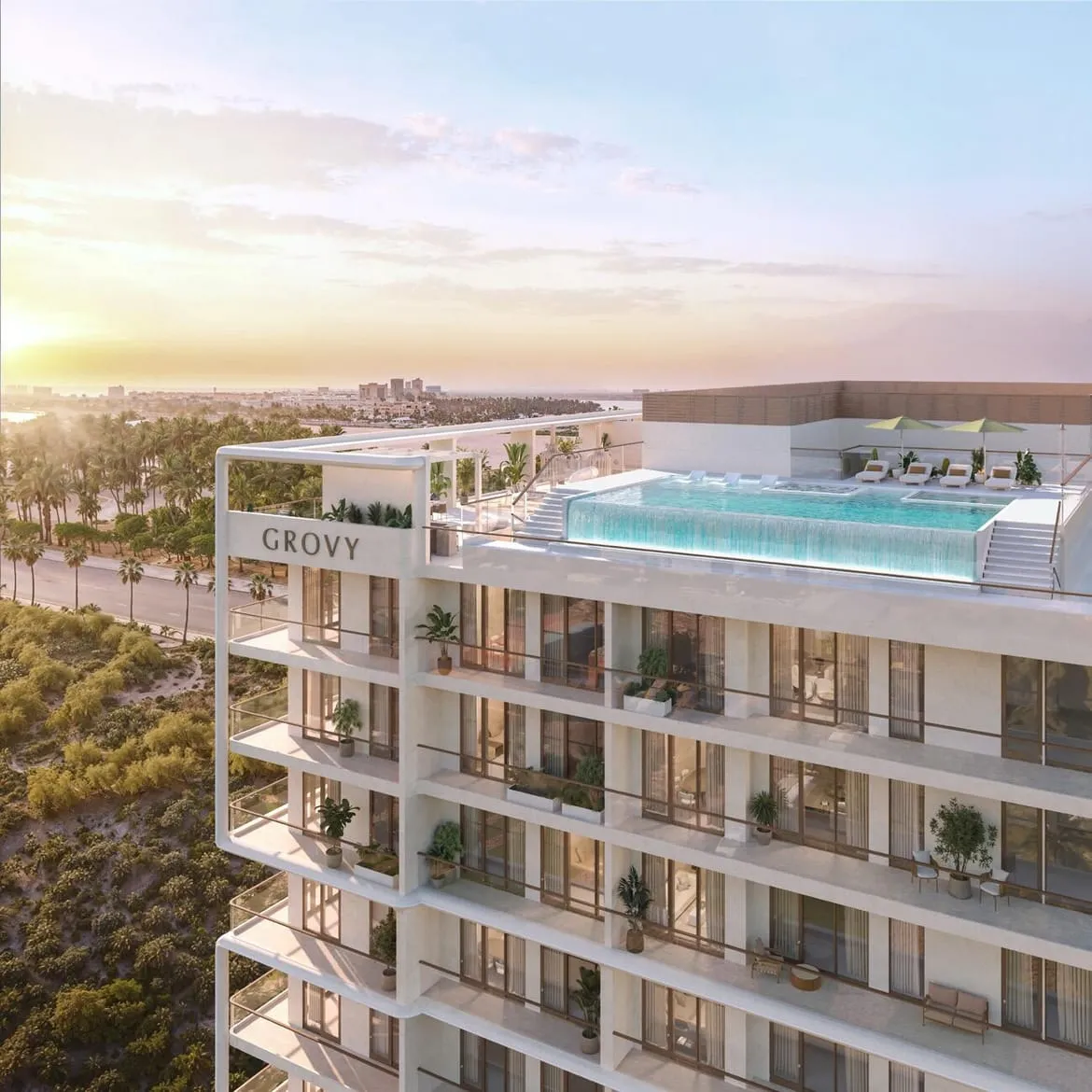 An aerial view at dusk showing the rooftop pool deck and the building's facade lit against the sky