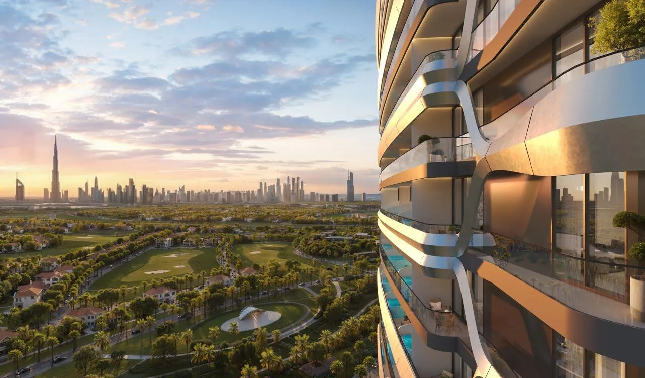 From a balcony at sunset, green open ground and tree clusters below with the distant skyline on the horizon