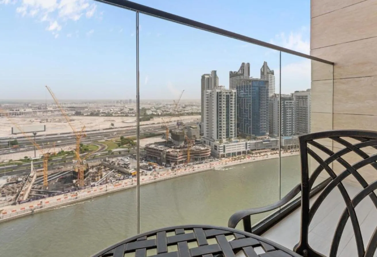 Photo of the balcony with a wrought-iron chair, looking over the canal