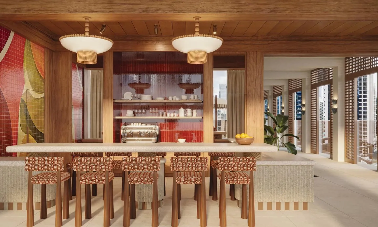 A bar counter with high stools, glass shelving behind it and a painted panel on the end wall