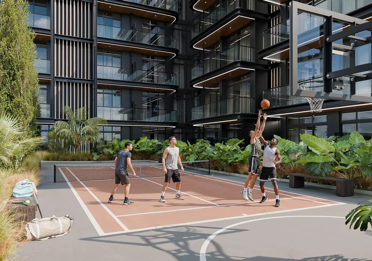 Residents playing on the community's basketball court beside the building.