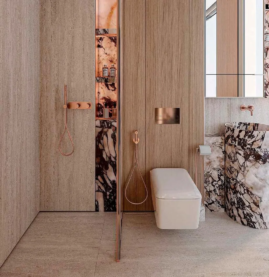 A walk-in shower lined in veined stone, a wall mounted rain head and the WC in the recess beyond