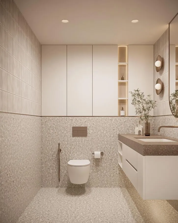 A terrazzo-tiled bathroom with a double mirrored vanity along the wall