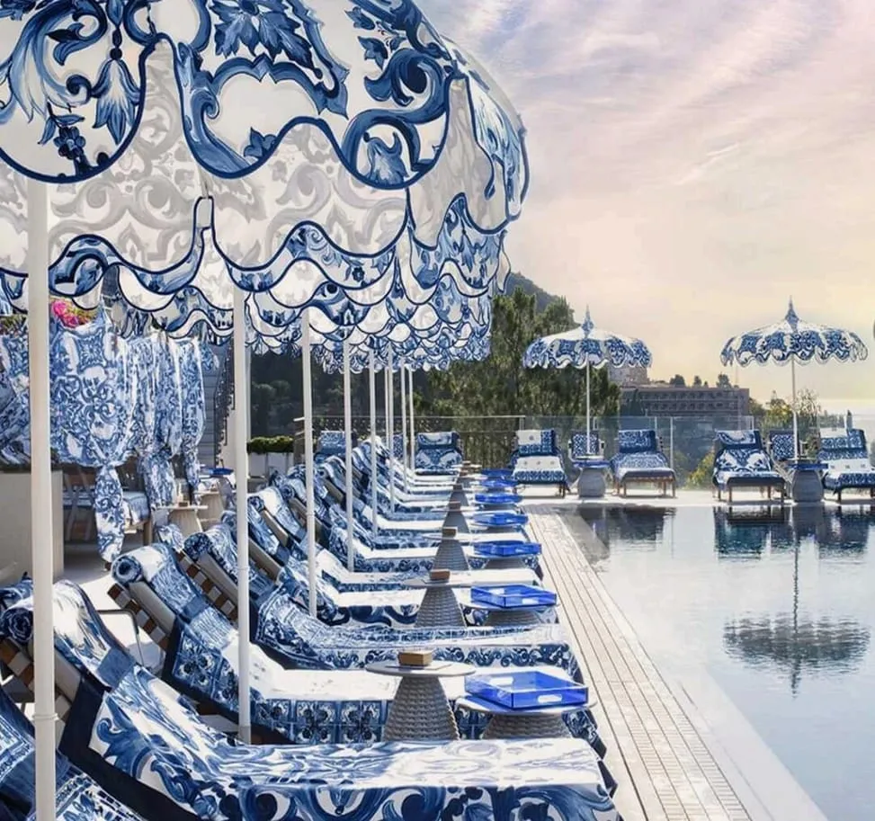 The beach club, patterned blue and white parasols and sunbeds running along the water's edge