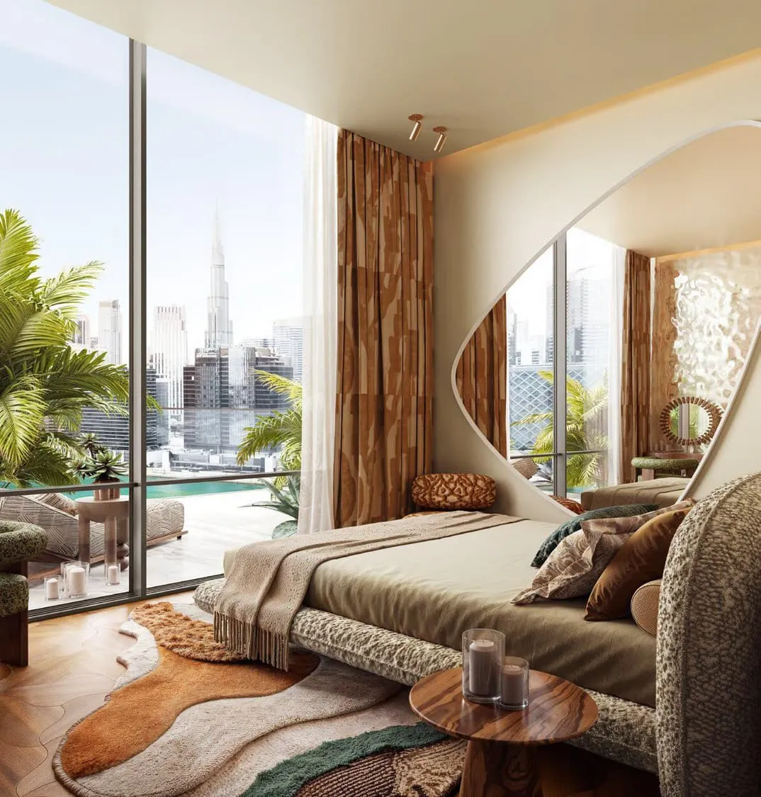A bedroom beside full height glass, the bed turned towards the Burj Khalifa with sheer curtains drawn back