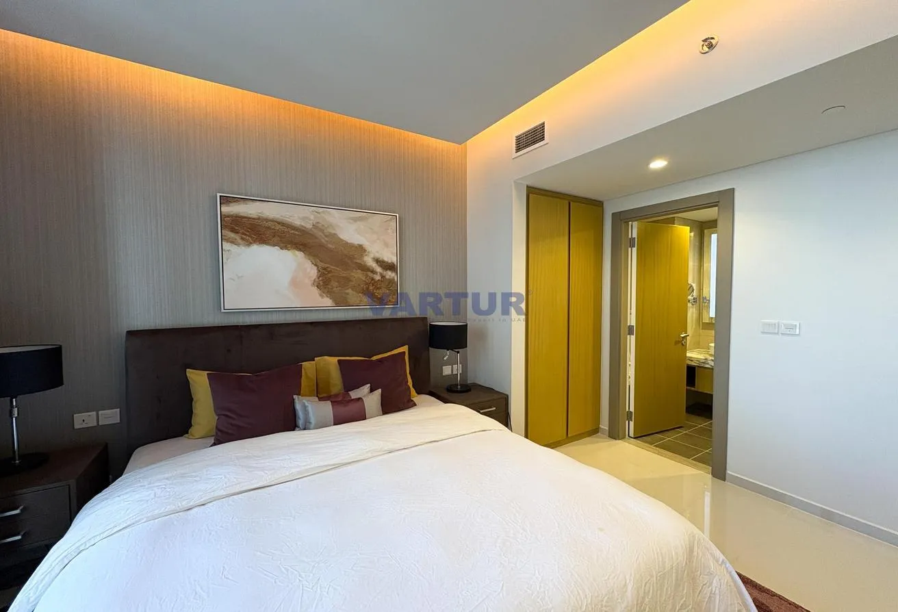 Photo of the bedroom, with a double bed beneath an abstract painting