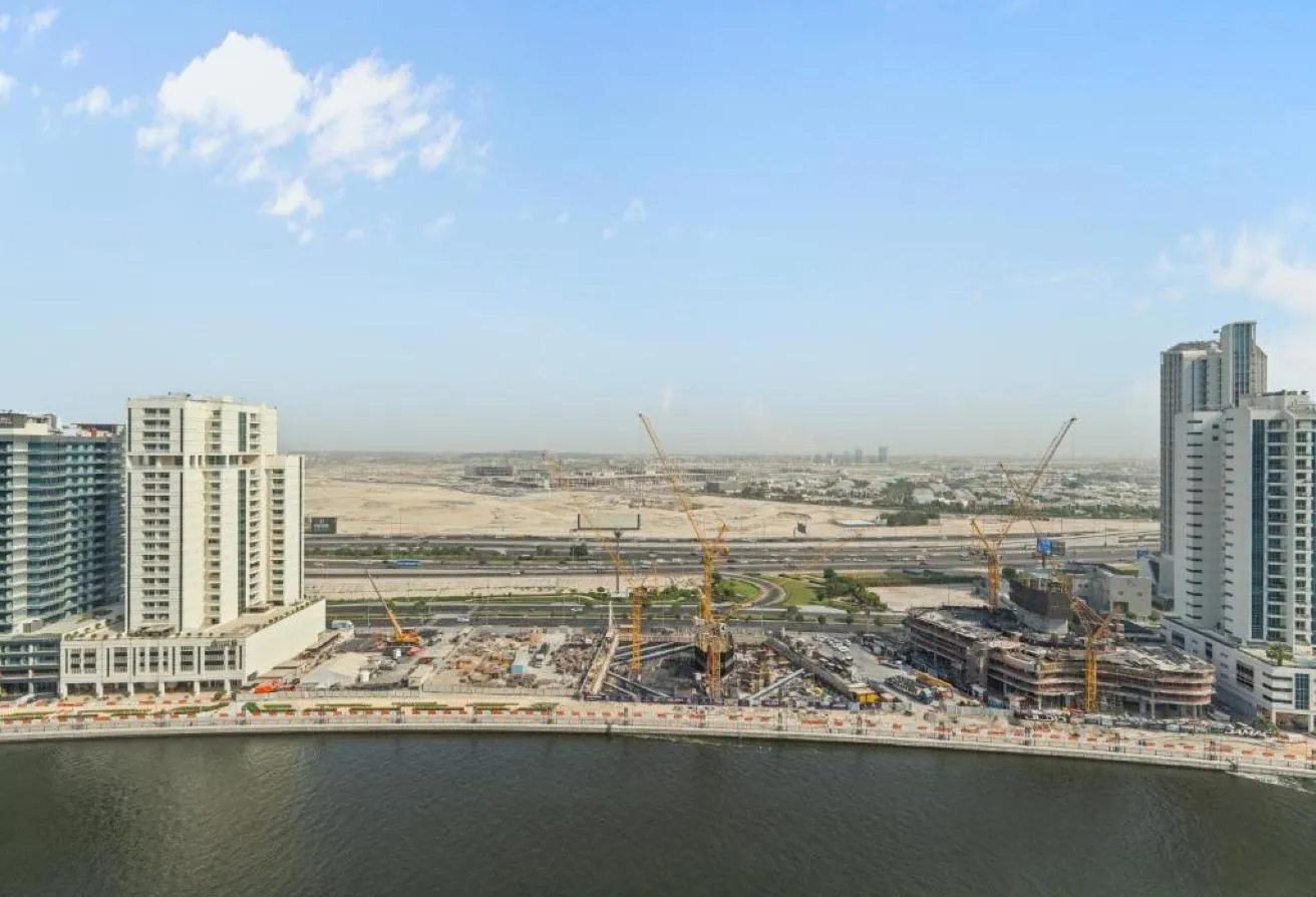 Photo of the view over the canal, with towers and construction sites on the far bank