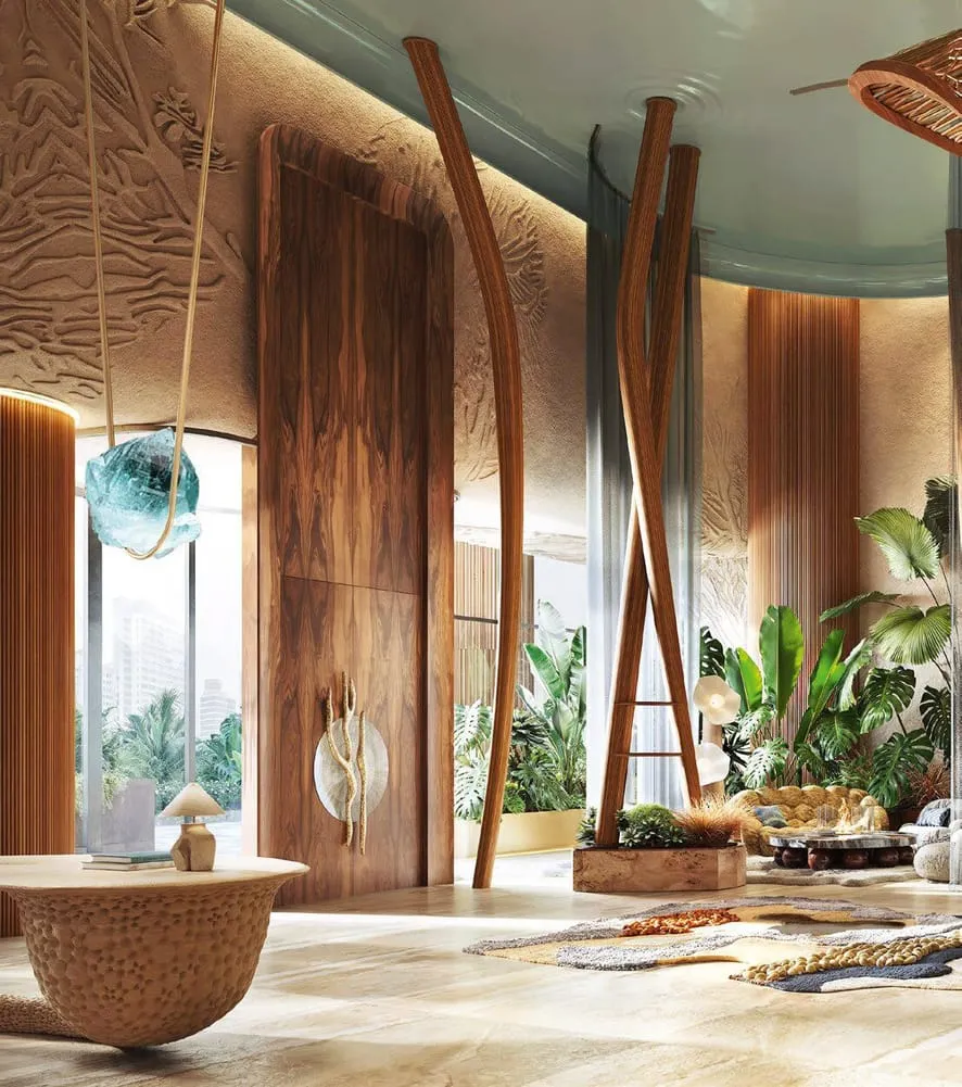 A room with a carved relief wall, a stone basin on a pedestal and tall bamboo standing either side of it