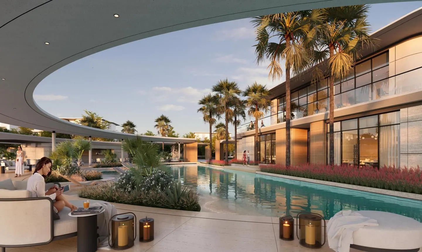 The clubhouse terrace at dusk, lit water and people seated beside the pool