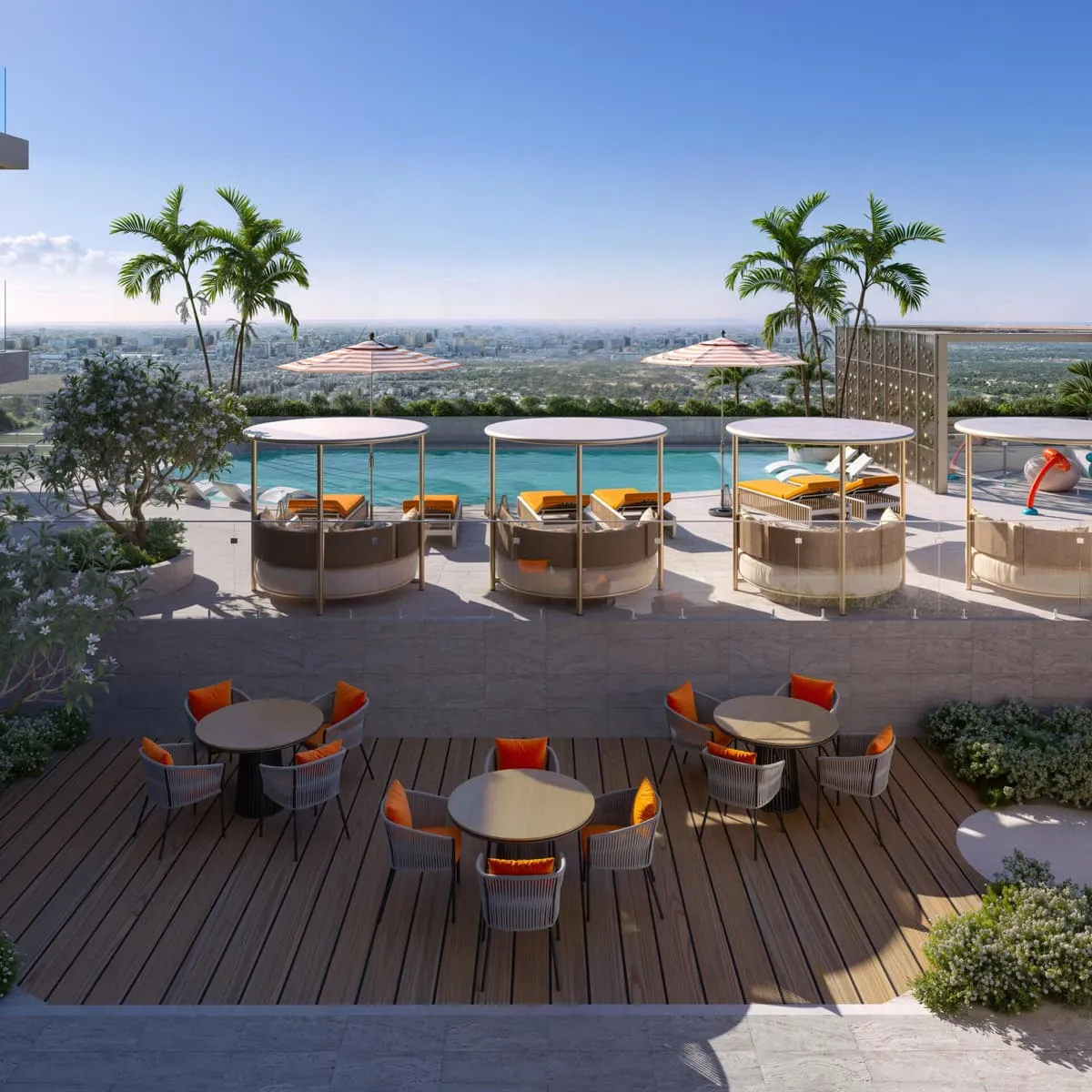 The deck laid out for dining, round tables and orange chairs between palms with the pool beyond