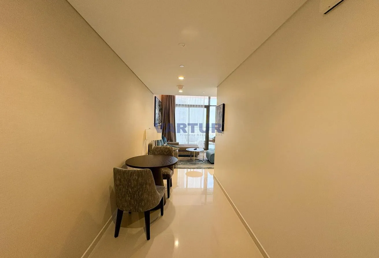 Photo of the entrance hall with a small dining table, leading to the living room