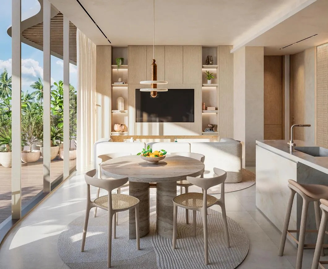 A dining area with a round table beside the open kitchen, under a warm timber ceiling