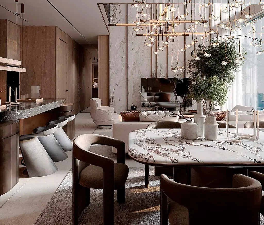 The dining table in white marble under a cluster pendant, rounded chairs and the kitchen behind