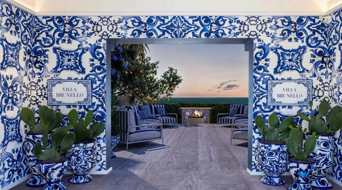 A tiled entrance portal in blue and white majolica, opening onto a shaded lounge with planted urns
