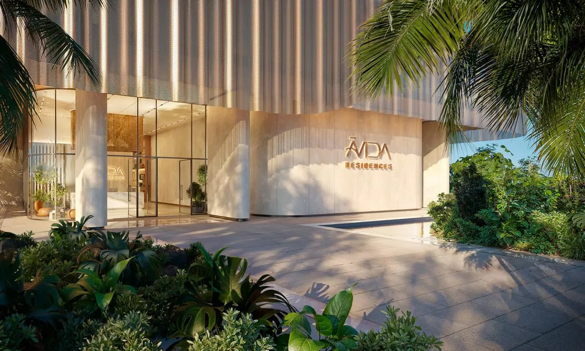The entrance to Avida Residences, gold lettering set into a timber-slatted wall among dense planting