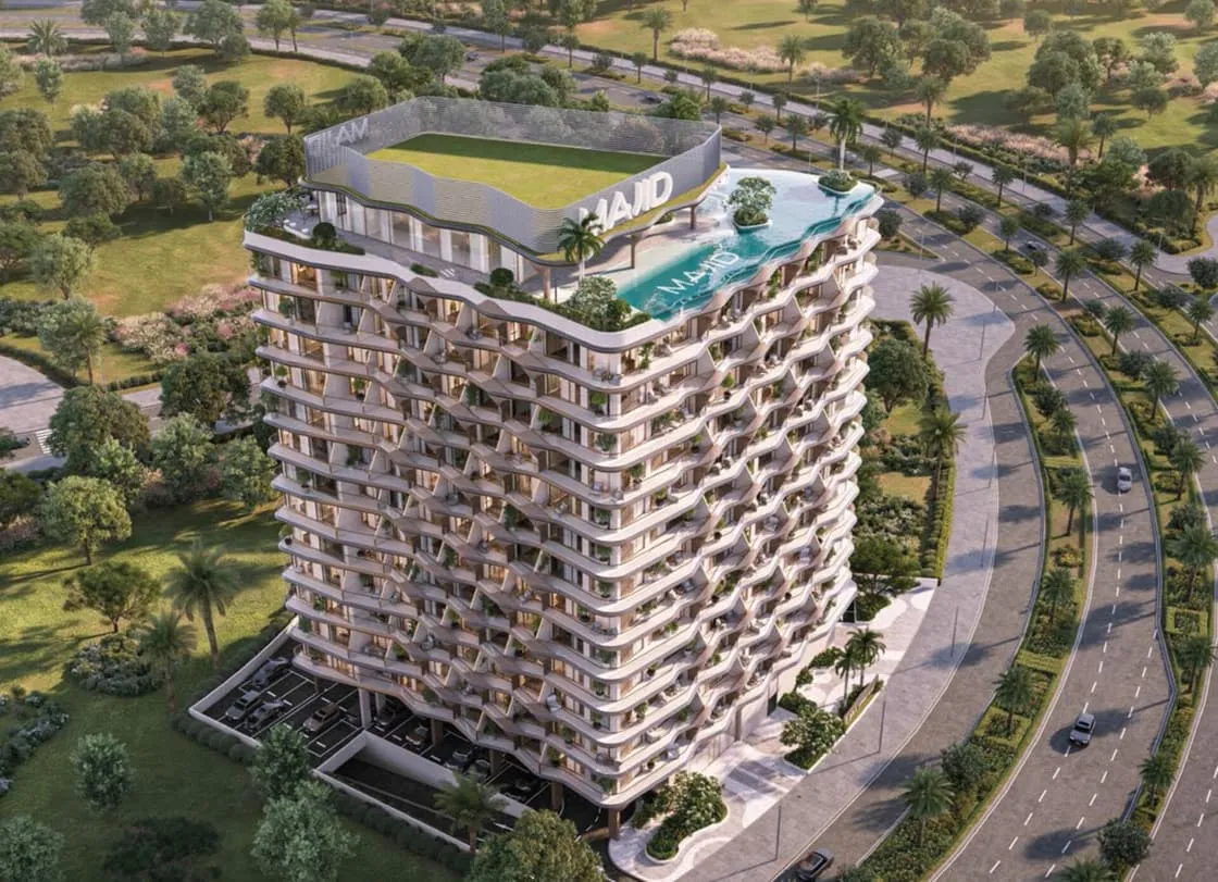The building from above, a lawn and a pool on the roof deck and a curving road wrapping the plot