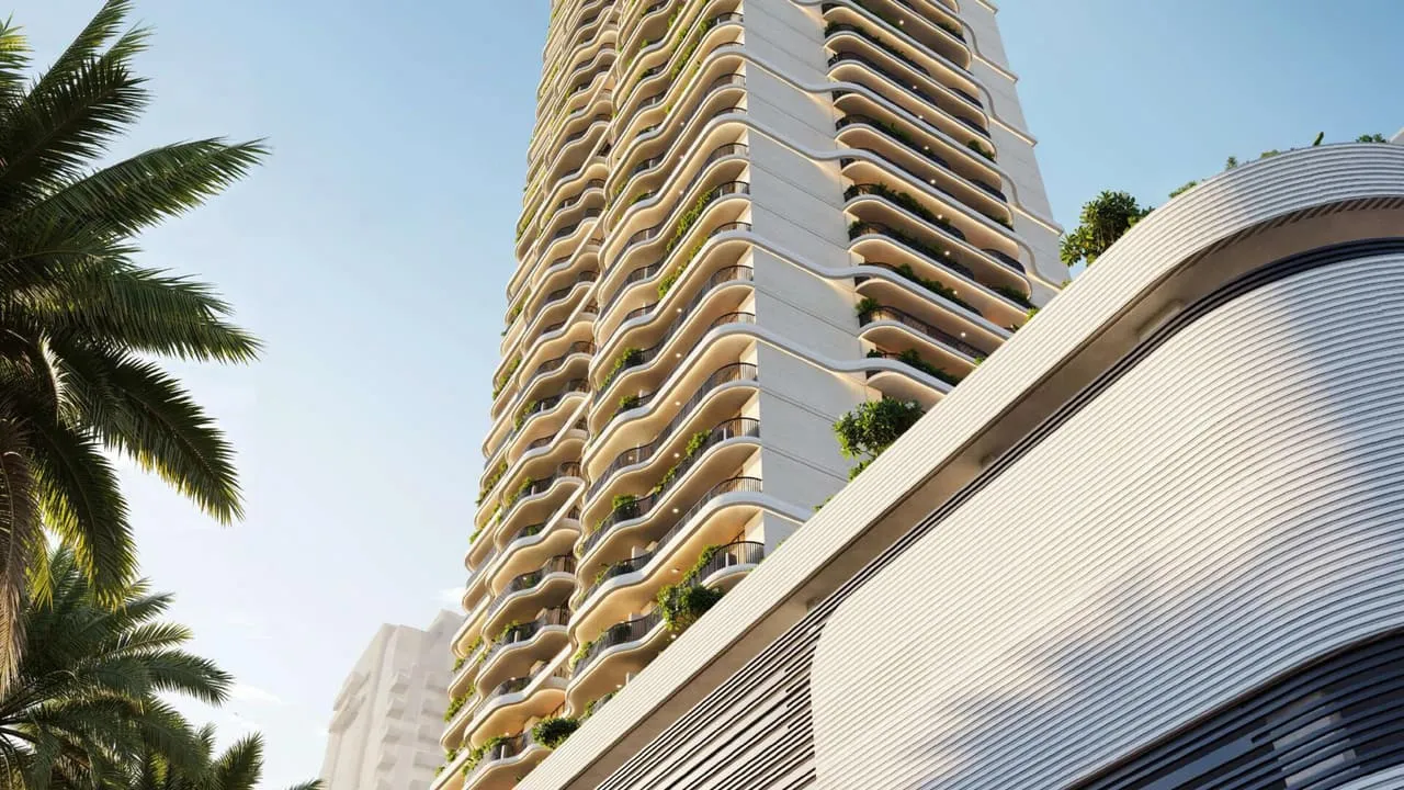 The facade close up, planting spilling from the curved balconies between palms
