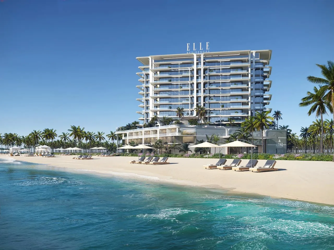 ELLE Residences seen from the beach, its curved white balcony terraces rising above the turquoise shallows and the sun loungers