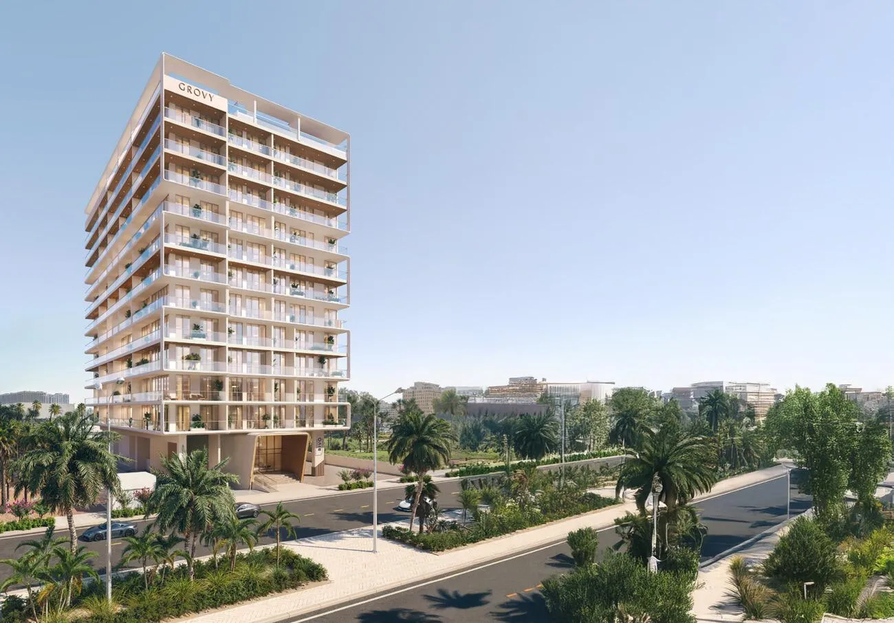 The building seen whole from the palm-lined boulevard, its stepped balconies catching the daylight
