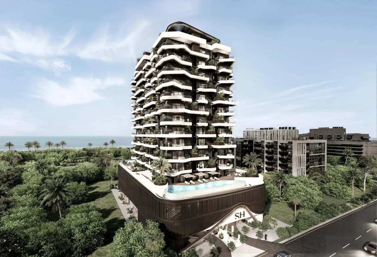 Marea Residences by day, its balcony-clad tower rising above palm trees with the sea beyond