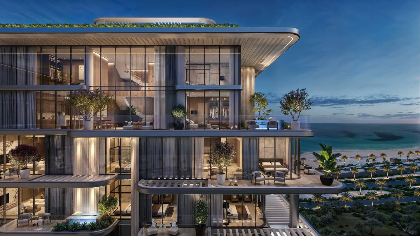 Villa del Divos at dusk, its glazed terraces lit from within above the beach on Dubai Islands