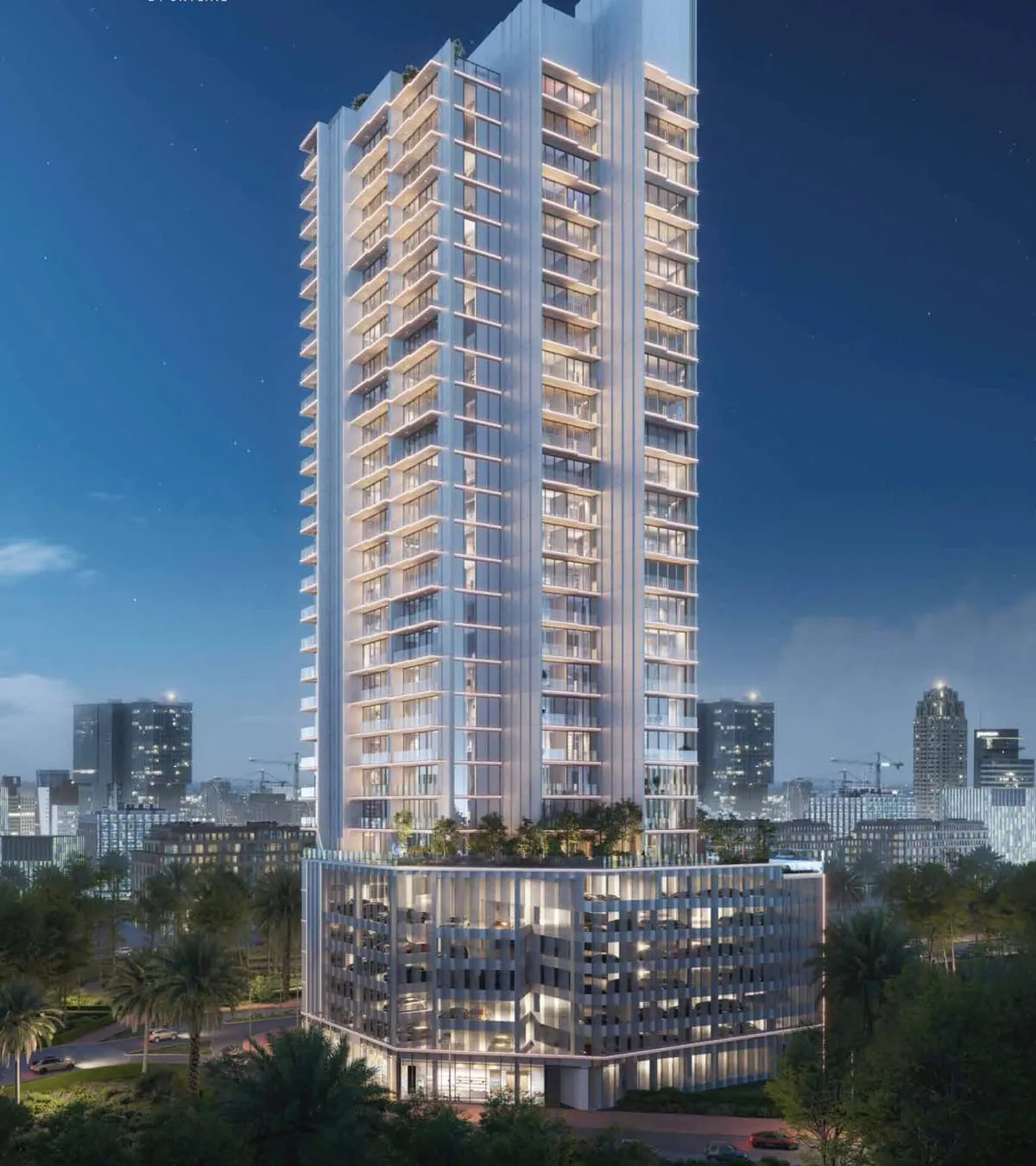 Avant Garde Residences 2 at dusk, the lit tower and its podium standing against the Jumeirah Village Circle skyline