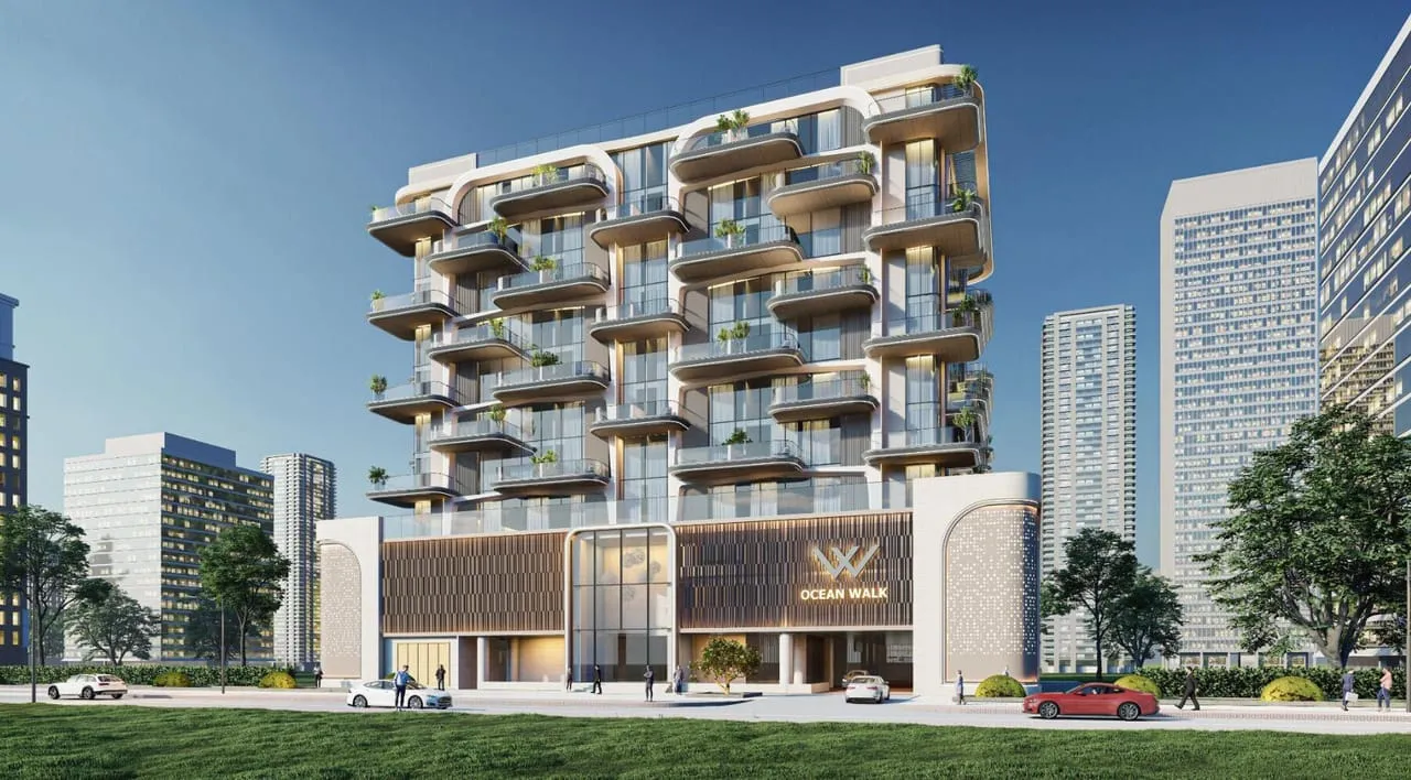 The building seen from the street, curved balconies stacked above an entrance marked Ocean Walk