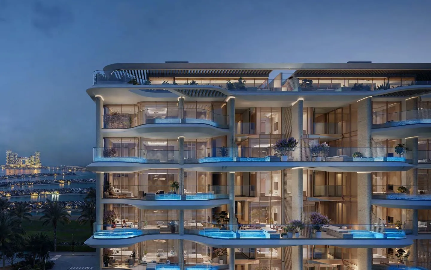 The building at night, the plunge pools on each balcony lit from within