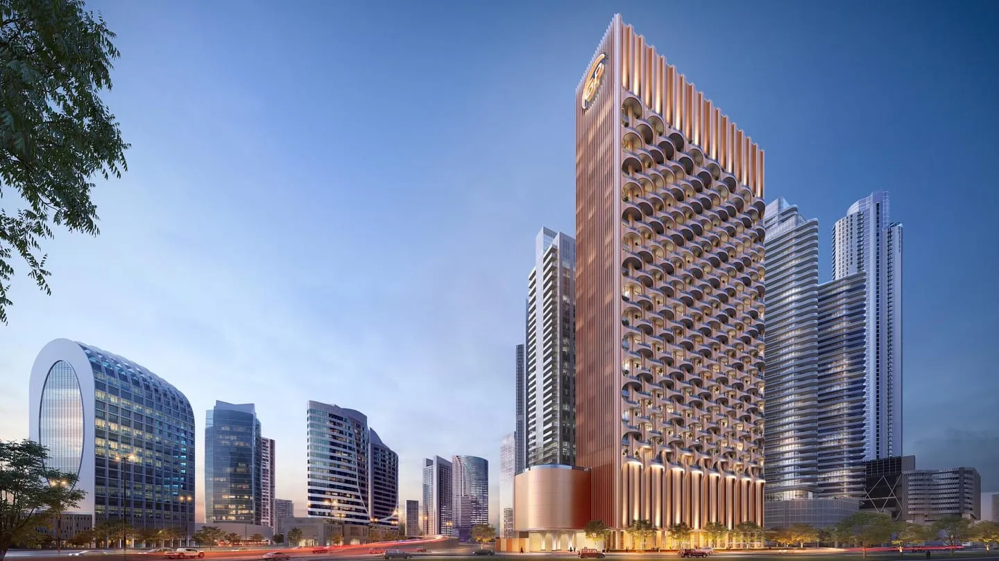 The tower from street level, its copper-toned lattice facade rising clear of the neighbouring blocks