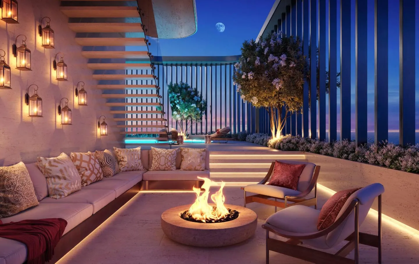 A sunken seating terrace at dusk, lanterns hung along the wall and a stone fire bowl at its centre