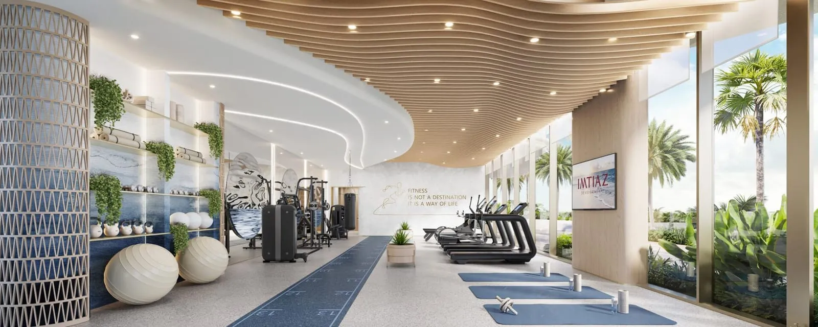A fitness area against a blue tiled wall, exercise balls and machines under a curved slatted ceiling