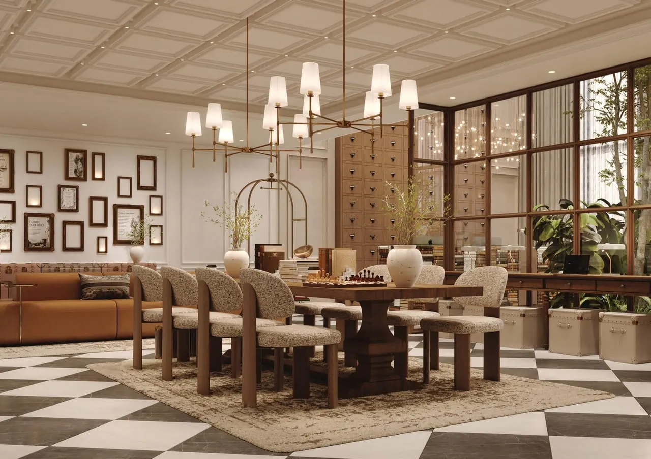 A games table set for chess under a chandelier, a card-catalogue wall behind and framed prints alongside