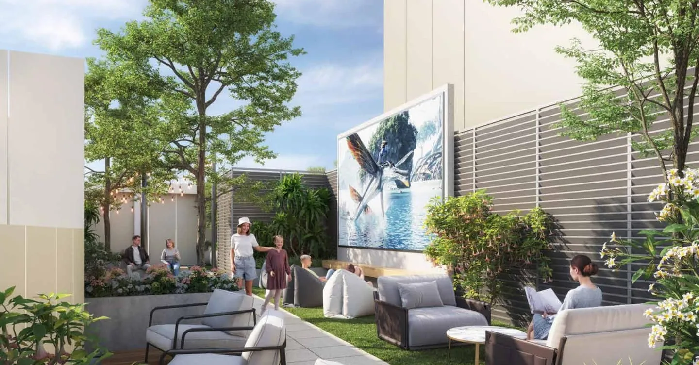 An outdoor lounge on the landscaped deck, armchairs and sofas gathered around a large outdoor screen