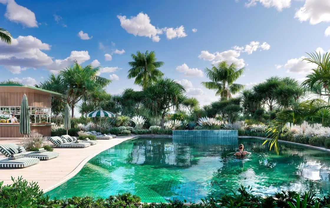 A pool set among palms with a timber pavilion at one end and a water wall at the other