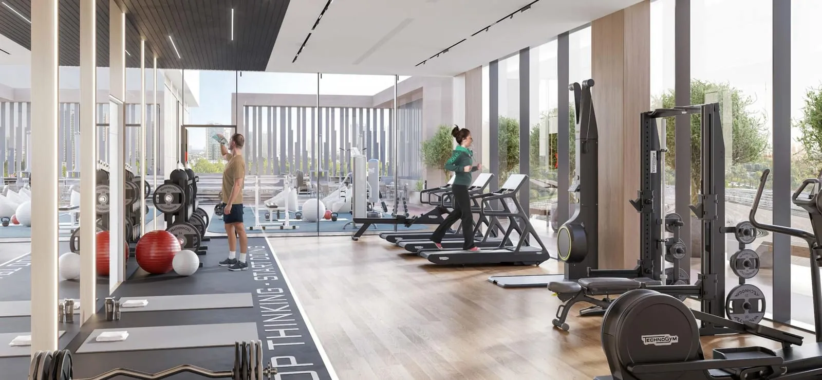 The indoor gym, treadmills and weight machines lined up along a fully glazed wall