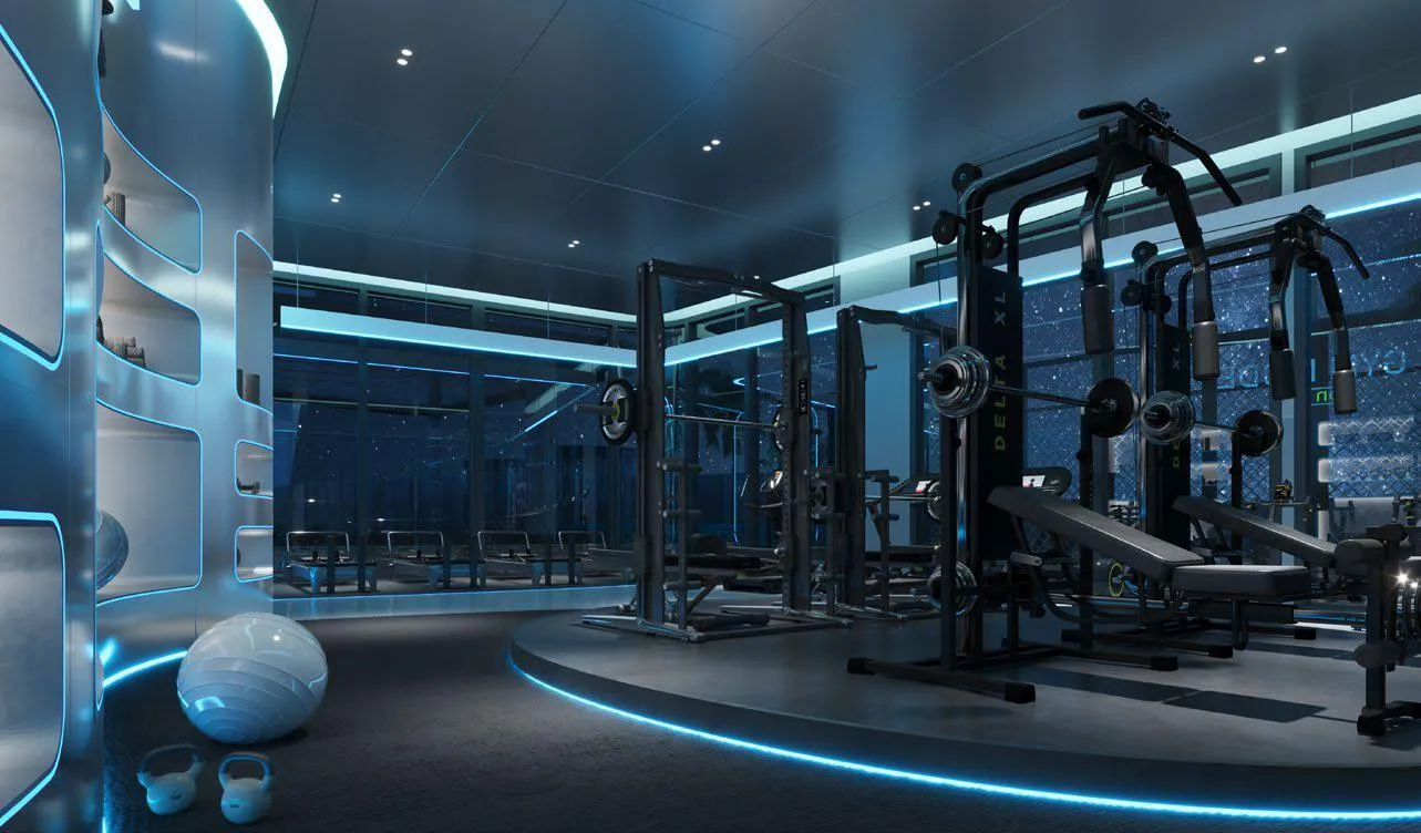 The strength side of the gym, weight racks and machines along a curved wall lit in blue