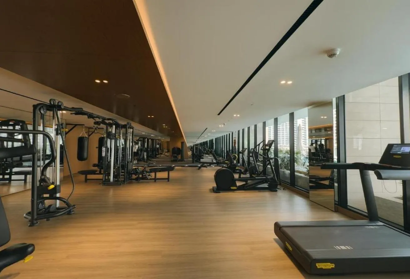 Photo of the gym, with weight machines and treadmills along a glass wall