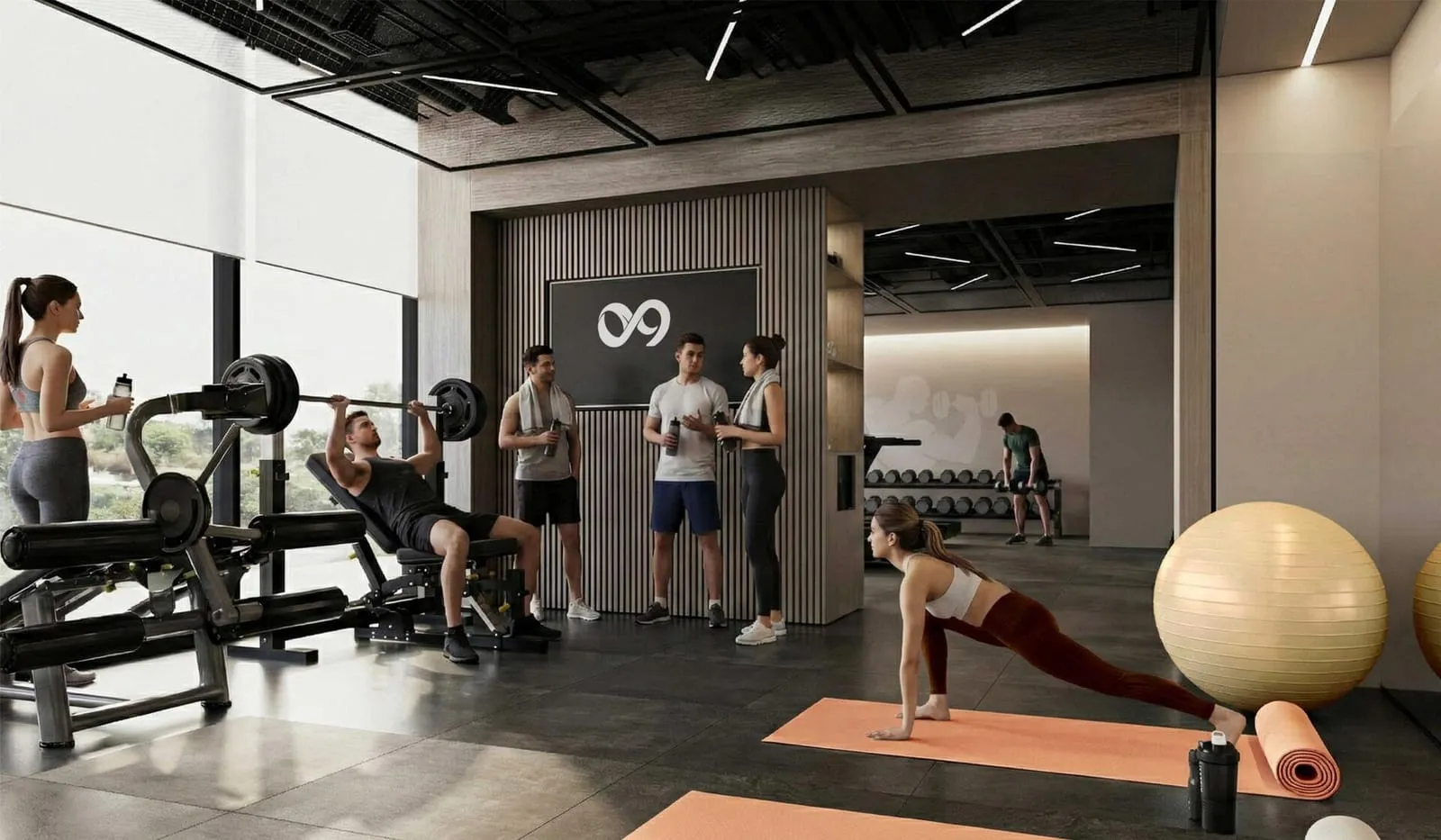 The gym, residents training among racks and free weights beneath the project's monogram