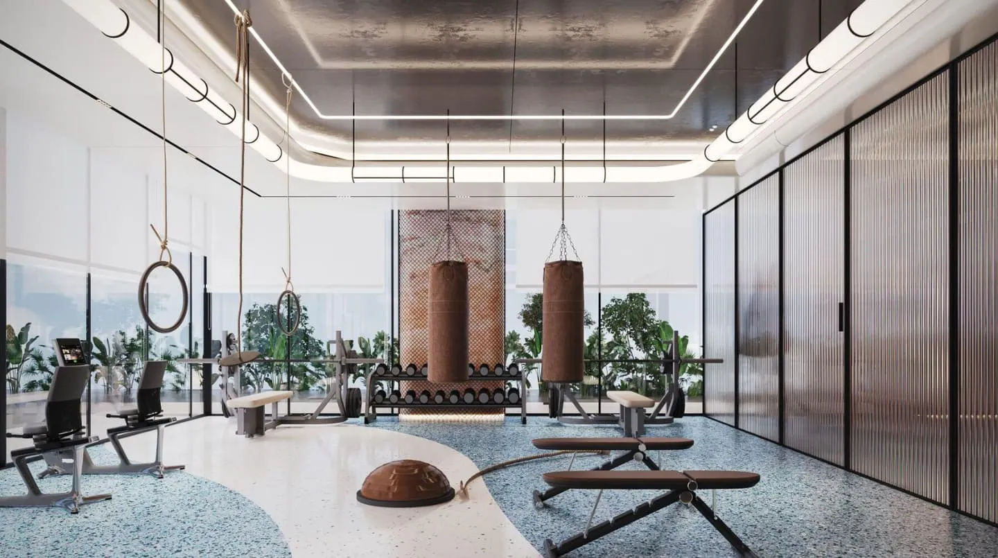 The gym, equipment set against a full-height window with a sea view