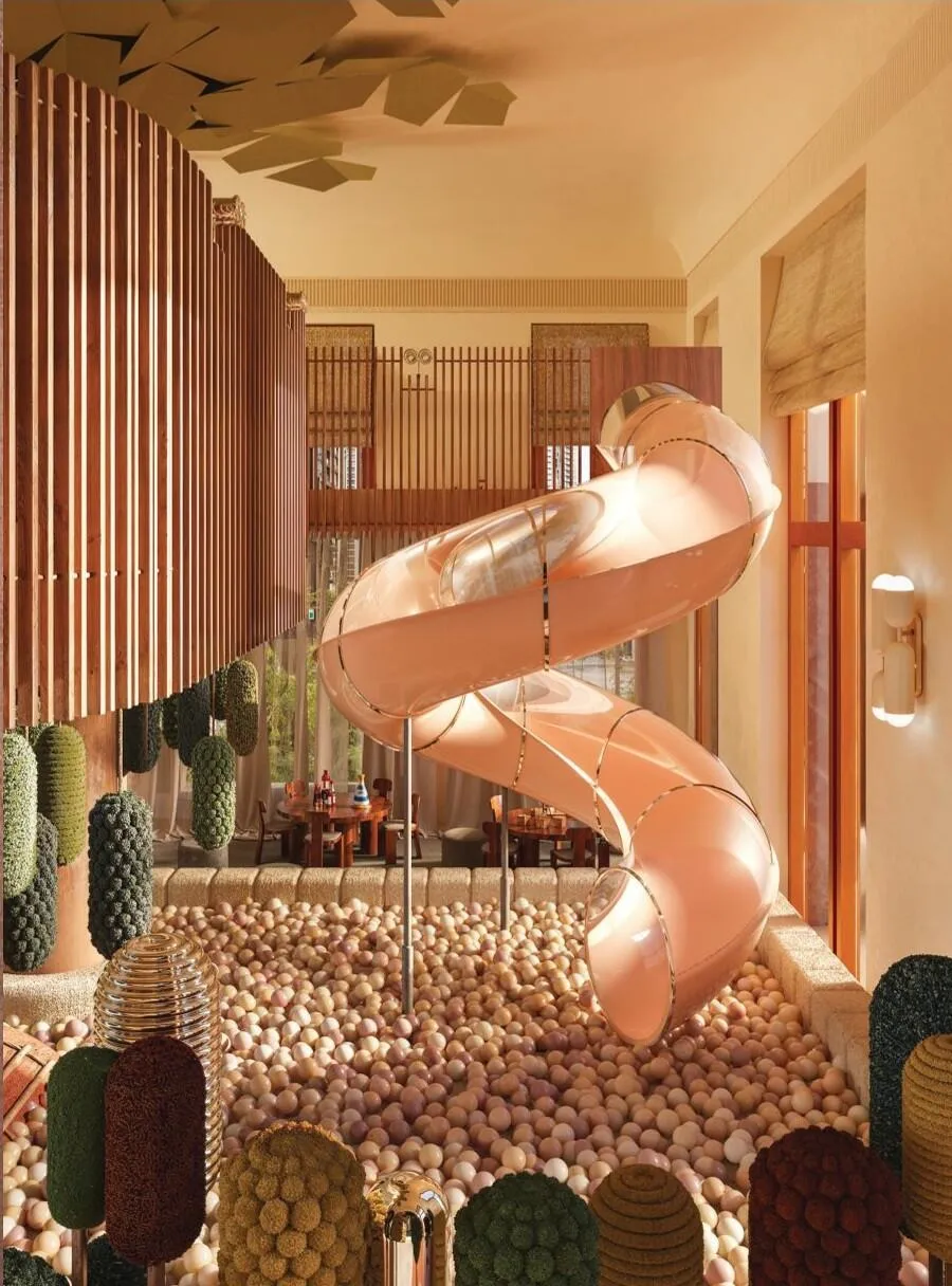 A children's play area with a spiral slide, soft shapes in green and pink across the floor