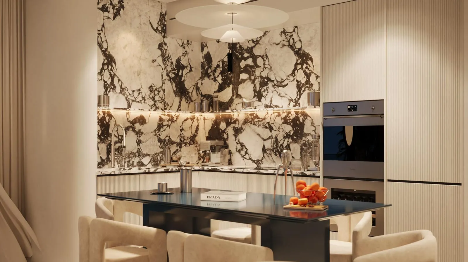 A kitchen wall of veined marble behind a dark island, with a built-in oven column and the dining table in front
