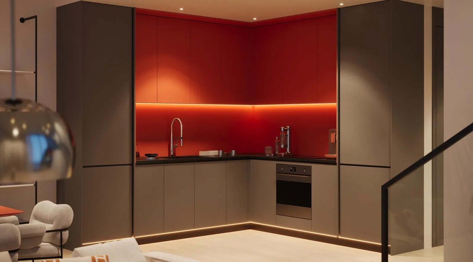 A kitchen in dark cabinetry with a red backlit splashback, the duplex staircase alongside