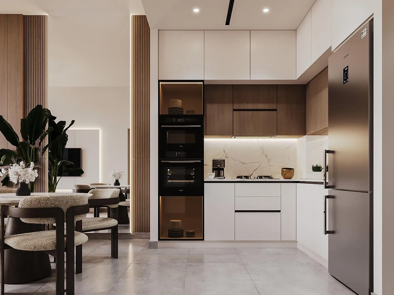A kitchen open to the dining table, pale cabinetry with an integrated oven column