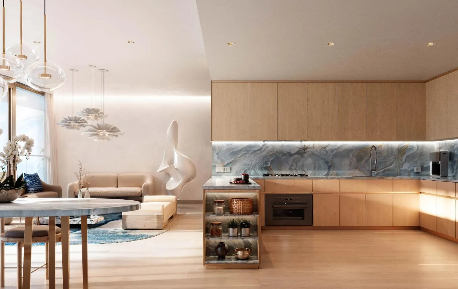 An open kitchen in pale timber with a veined stone splashback, a glass-fronted island and the living room beyond