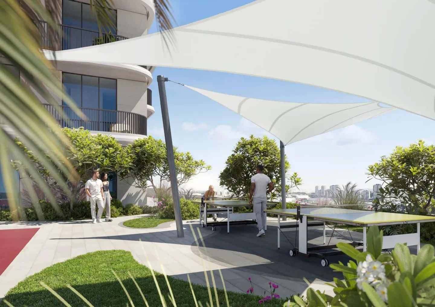 A lawn under white sail canopies, people crossing the grass toward the building