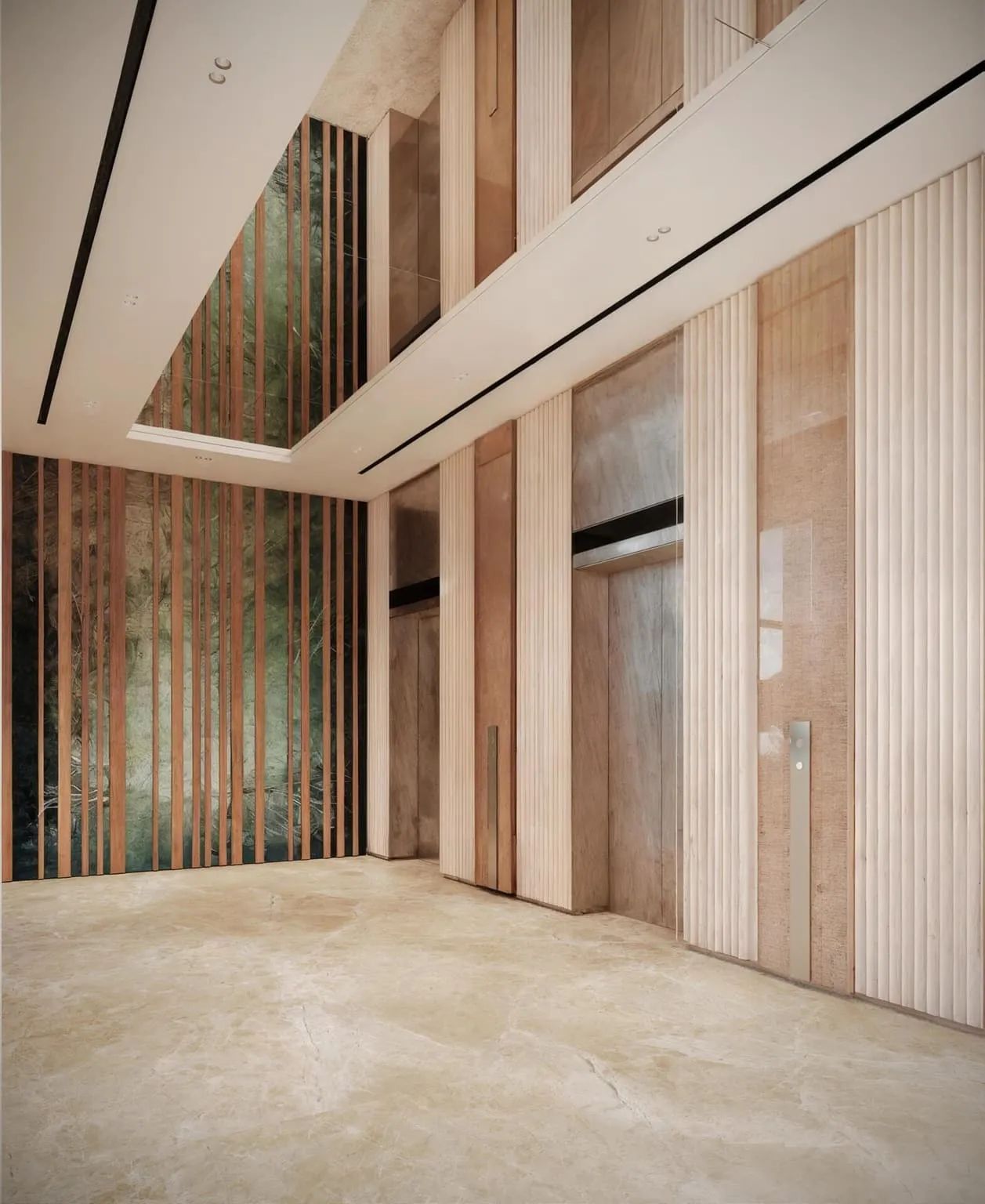 The lift lobby, brushed metal doors set into a wall of vertical timber with light washing down it
