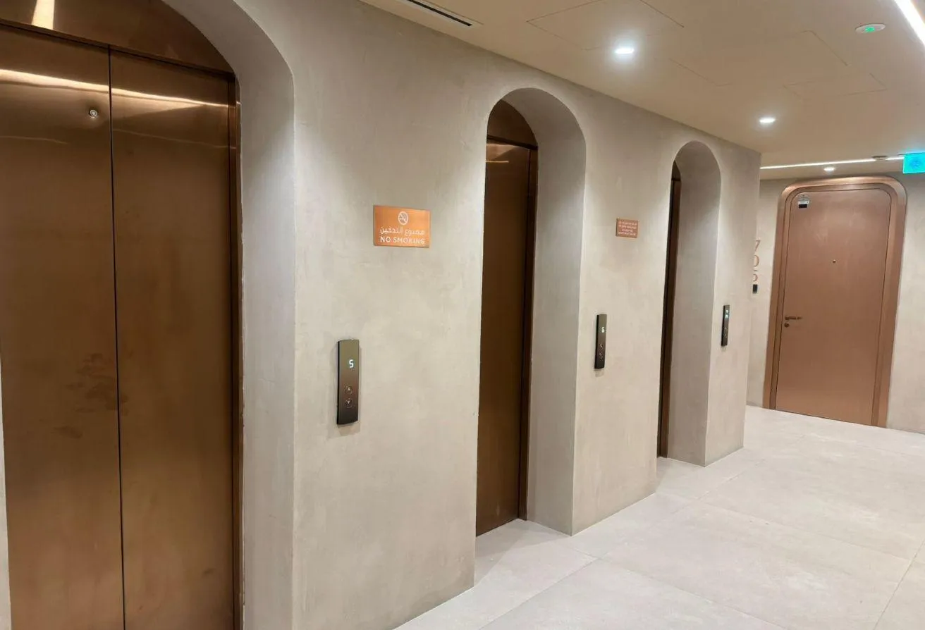 Photo of the lift lobby, with bronze lift doors and arched openings