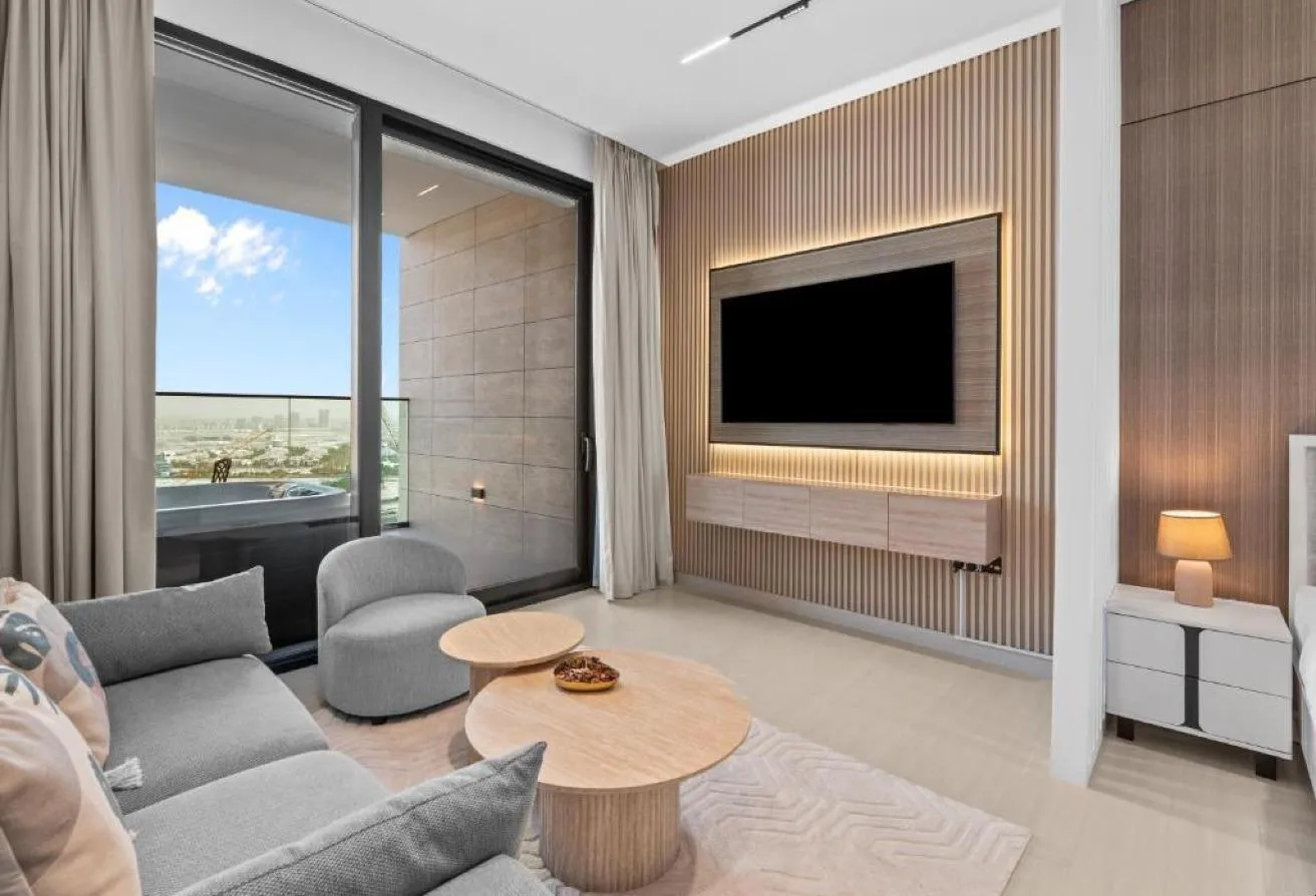 Photo of the living area, with a panelled TV wall and a sliding door to the balcony