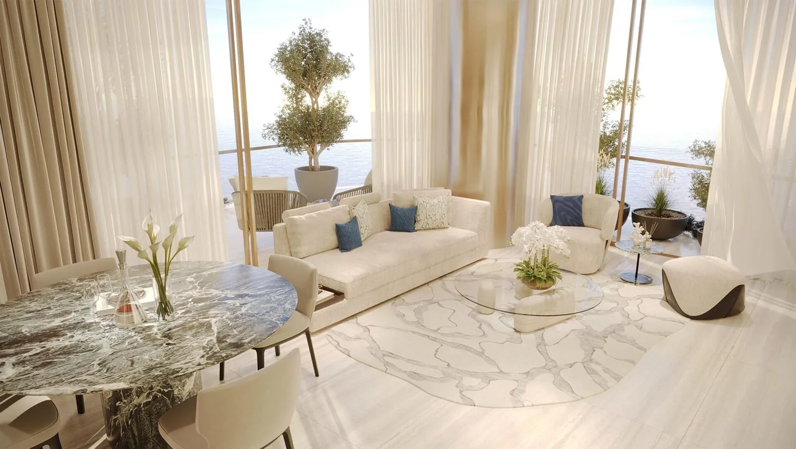 Open living and dining lounge finished in soft cream tones with marble accents.